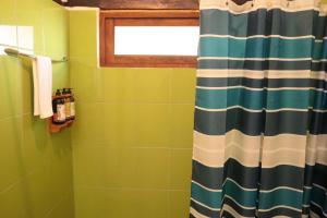 a bathroom with a shower curtain and a window at Hotel Venus de Valdivia Aeropuerto in Tababela