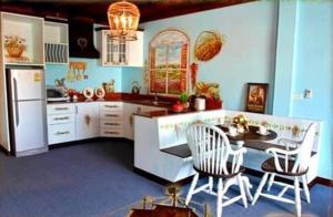 eine Küche mit Tisch und Stühlen und einem Kühlschrank in der Unterkunft The Colored House Jomtien in Jomtien Beach + 31 Fotos