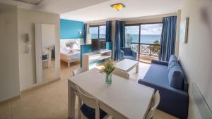 ein Wohnzimmer mit einem blauen Sofa und einem Tisch in der Unterkunft Prope Mare Apartamentos in Cala Millor