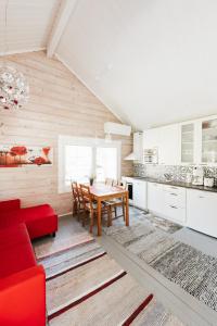 a kitchen with a wooden table and a red couch at Pikku Torppa Cottage in Kotka