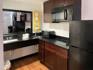 uma cozinha com um frigorífico de aço inoxidável e um lavatório em Studio 6 Houston TX Brookhollow em Houston