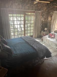 Tempat tidur dalam kamar di JakkalsDraai River Bush Lodge
