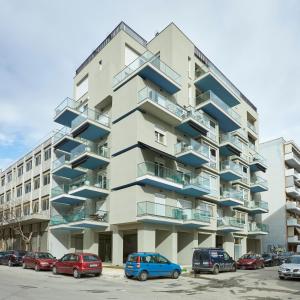 an apartment building with cars parked in a parking lot at Olea Apartments in Thessaloniki