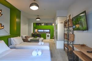 a living room with two beds and a green wall at Olea Apartments in Thessaloniki