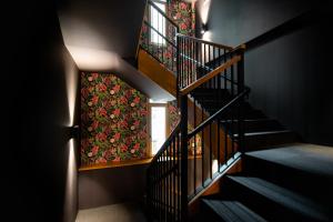 a spiral staircase with a floral wallpaper on the wall at Hotel Atari in Donostia-San Sebastián
