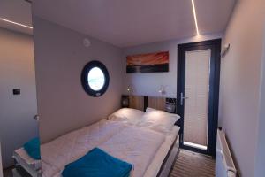 ein kleines Schlafzimmer mit einem Bett und einem Fenster in der Unterkunft Hausboot Fjord Lacerta mit Dachterrasse in Wendtorf in Wendtorf