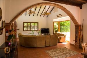 a living room with a large couch and an archway at Wanakaset Panama in Dolega