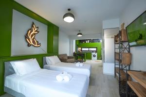 two beds in a room with green walls at Olea Apartments in Thessaloniki