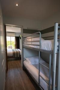 two bunk beds in a room with a mirror at Logis Hotel Restaurant L'Escapade in Le Pêchereau