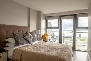 1 dormitorio con 1 cama y vistas al océano en Galway Bay Sea View Apartments, en Galway