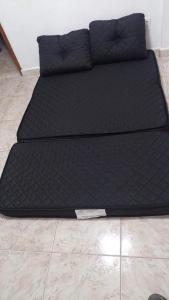 a black bed with a knife on the floor at 100 mts Praia Ar Condicionado Wi-Fi 600 Roupa Cama Toalha 24 hs in Santos +48 photos