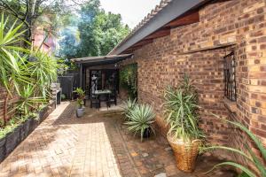 a brick house with potted plants in a courtyard at Hello Sunshine Self Catering Studio Apartments in Nelspruit