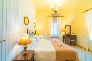 a bedroom with a bed with a lamp and a desk at Archontiko Eleni Hotel in Andros