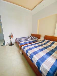 1 Schlafzimmer mit 2 Betten und einem Ventilator in der Unterkunft O Vững's Homestay in Vũng Tàu + 9 Fotos