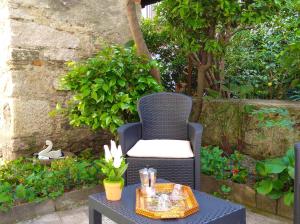 einen blauen Korbstuhl und einen Tisch im Garten in der Unterkunft Miryam in Baveno