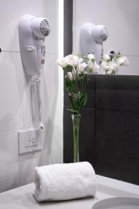 een vaas met bloemen op een aanrecht in een badkamer bij Urbanica The Libertador Hotel in Buenos Aires