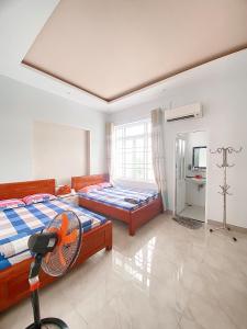 ein Schlafzimmer mit zwei Betten und einem Fenster in der Unterkunft O Vững's Homestay in Vũng Tàu