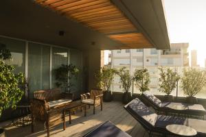 - un balcon avec des chaises et des tables dans un bâtiment dans l'établissement Urbanica The Libertador Hotel, à Buenos Aires