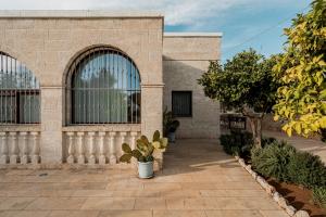 un edificio in mattoni con due grandi finestre e piante di VILLA OSTUNI ONE mit Pool, Gästehaus & Glamping a Ostuni