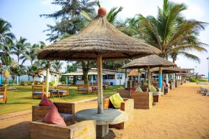 a resort with tables and umbrellas on a beach at Hotel Riviera Ramatou Plage in Lomé
