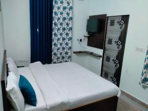 um pequeno quarto com uma cama e uma televisão em ASHOKA PALACE em Sawai Madhopur