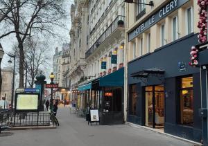 een straat met winkels en gebouwen op een stoep bij Hotel Le Clery in Parijs