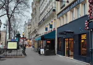 a city street with shops and buildings on a sidewalk at Hotel Le Clery in Paris