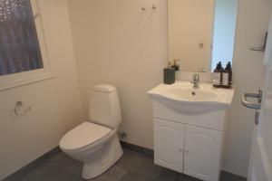 a white bathroom with a toilet and a sink at 102 Fyrrelunden (id. 083) in Esbjerg