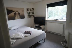 a small bedroom with a bed and a television at 102 Fyrrelunden (id. 083) in Esbjerg