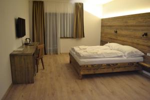 Dormitorio con cama, escritorio y TV en Tri kopy*** - penzión, reštaurácia a pizza, en Smrečany