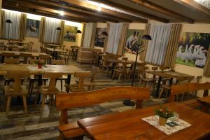 un restaurante con mesas de madera, sillas, mesas y una mesa en Tri kopy*** - penzión, reštaurácia a pizza, en Smrečany