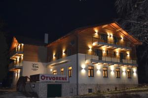 un edificio de apartamentos iluminado por la noche en Tri kopy*** - penzión, reštaurácia a pizza, en Smrečany