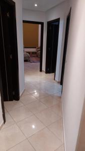 korytarz z podłogą wyłożoną kafelkami i czarnymi szafkami w obiekcie ESPACIOSO w mieście Tanger