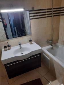uma casa de banho com um lavatório branco e uma banheira em ESPACIOSO em Tânger