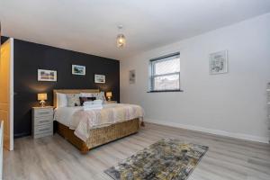 a bedroom with a bed and a black wall at In the heart of it! in Stokesley