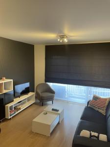 een woonkamer met een bank en een stoel bij Louisa2 in Oostende