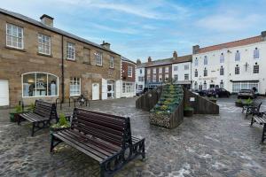 a group of benches in a courtyard with buildings at In the heart of it! in Stokesley