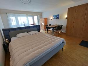 a large bed in a bedroom with a table and chairs at Erli 13 in Leukerbad