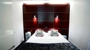 a hotel room with a bed with two pillows at Logis Hôtel Relais de Vincey in Vincey +28 photos
