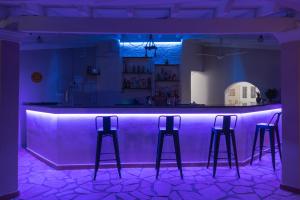 eine lila Bar mit drei Barhockern in einem Zimmer in der Unterkunft Euphoria complex in Kavos