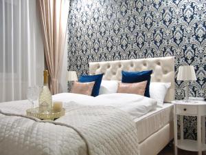 1 dormitorio con cama blanca y papel pintado azul y blanco en ZB Apartment Luxor Bobrowniki Rogożnik Pyrzowice, 