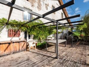 a pergola with a table and a bench on a patio at La Maison de Max - avec terrasse in Saulxures-sur-Moselotte