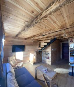 a living room with a blue couch and a wooden ceiling at Family home MASA in Žabljak