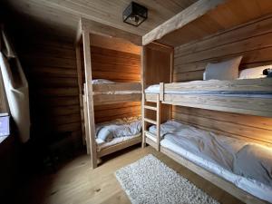 イドレにあるNewly built modern cottage near skiing and golf in Idreの木製の壁の客室で、二段ベッド2組が備わります。