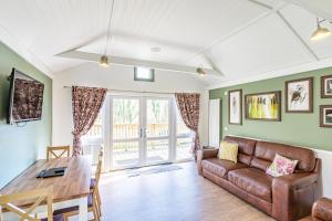a living room with a couch and a table at Squirrel Lodge 40 with Hot Tub in Newton Stewart