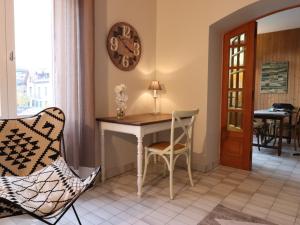 アヌシーにあるAppartement Annecy, 4 pièces, 6 personnes - FR-1-432-43のテーブルと椅子、壁に時計が備わる客室です。