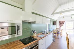 a kitchen with white cabinets and a counter top at Squirrel Lodge 40 with Hot Tub in Newton Stewart