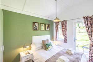 ニュートン・スチュワートにあるSquirrel Lodge 40 with Hot Tubのベッドと窓のある寝室