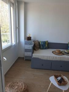 Habitación con cama, mesa y ventana en Studio refait à neuf Ave St Maurice, en Palavas-les-Flots