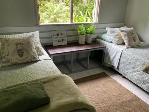 a bedroom with two beds and a window with plants at Solar 197 Pousada in Timbó